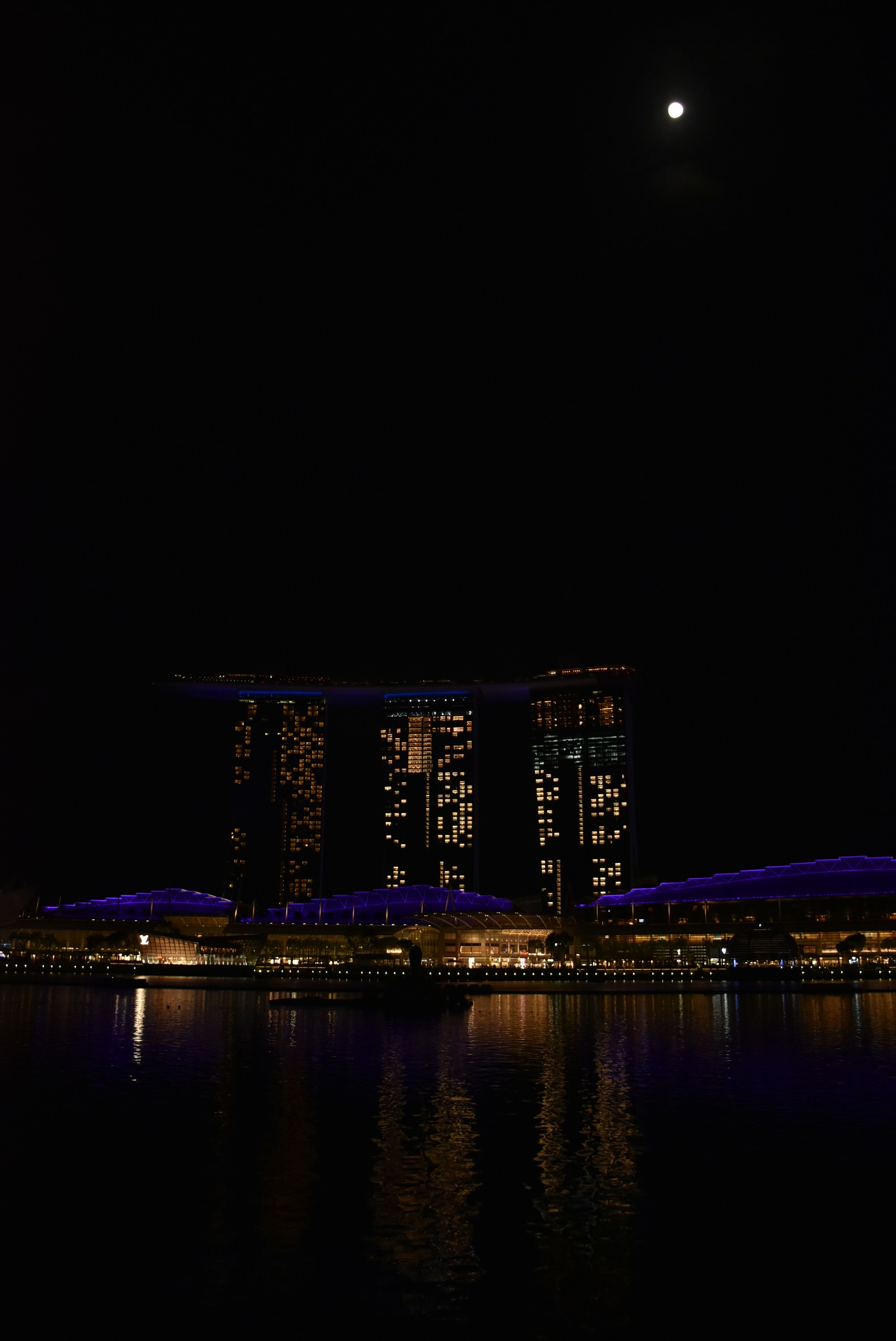 a full moon shines in the night sky over a city