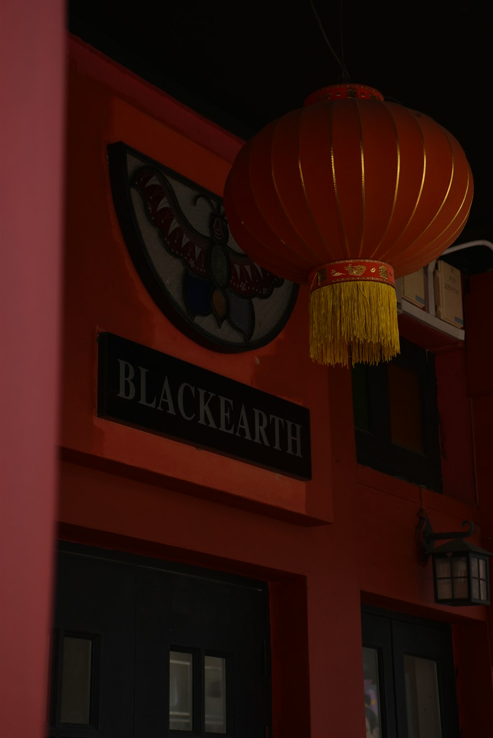a red building with a red lantern hanging from it's side