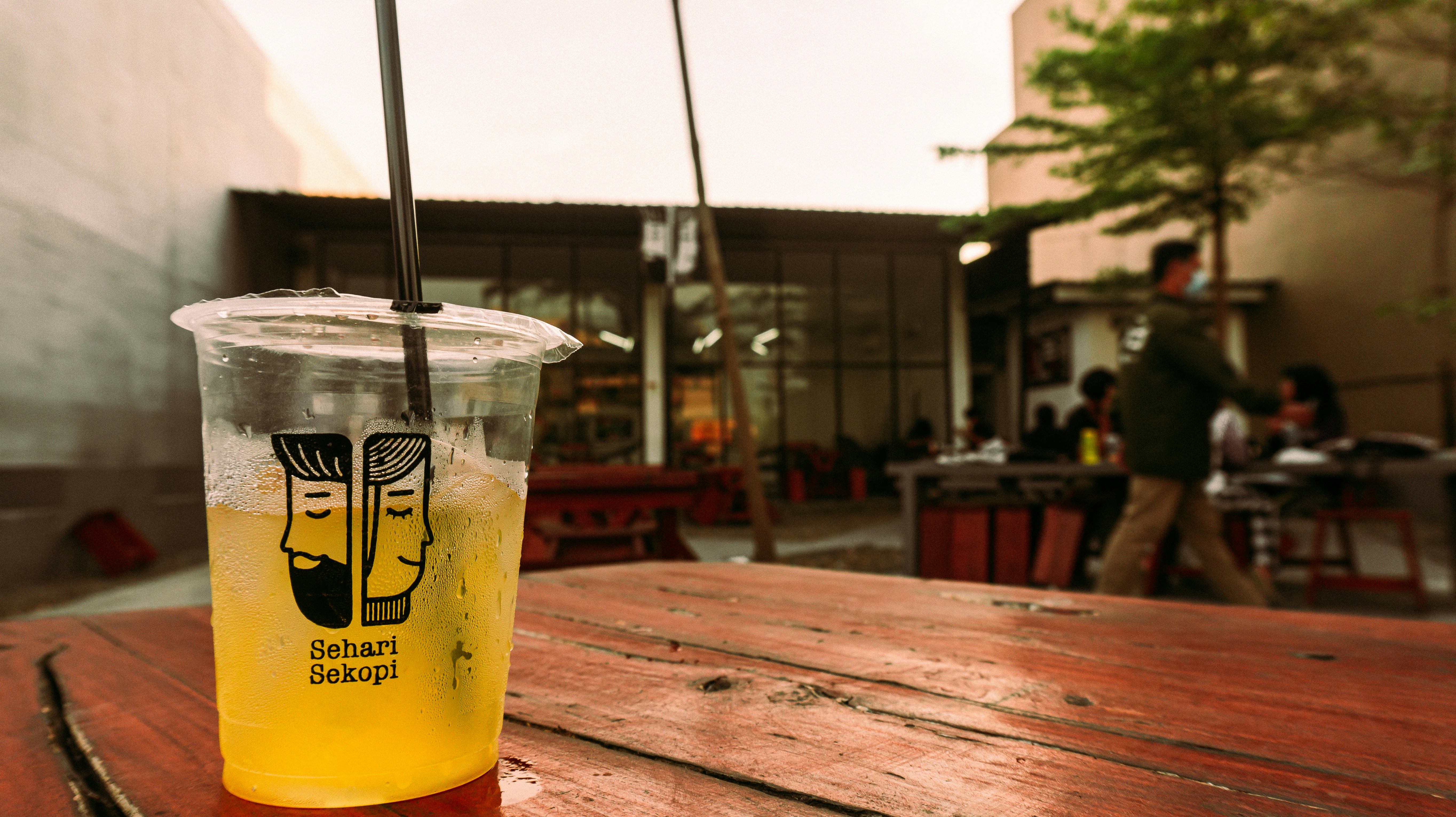 Un vaso de limonada sentado encima de una mesa de madera