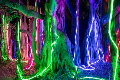 Close-up of sleek sensor units mounted on tree trunks with glowing neon green accents.