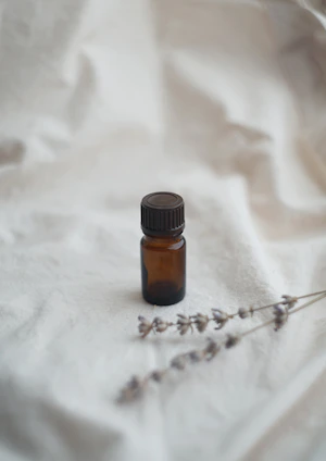 a bottle of essential oils sitting on a white sheet