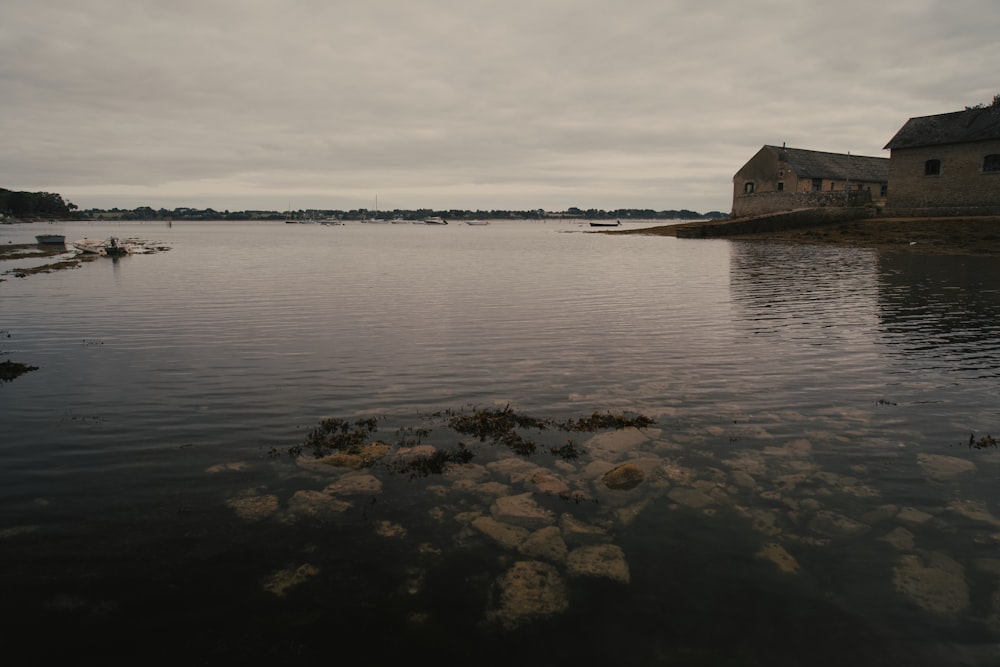 a body of water with a house in the background