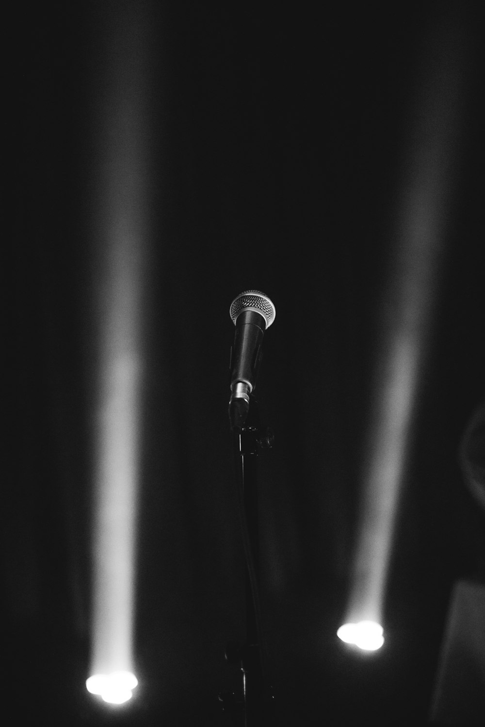 a black and white photo of a microphone and lights