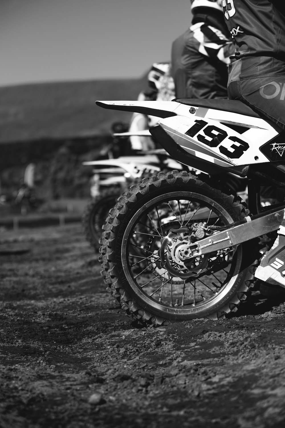 a black and white photo of a person on a dirt bike