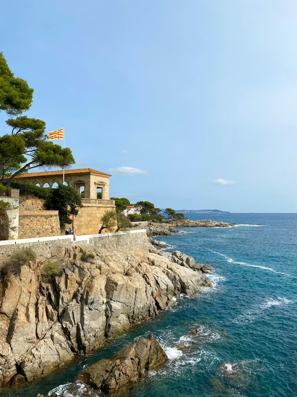 a house sitting on top of a cliff next to the ocean