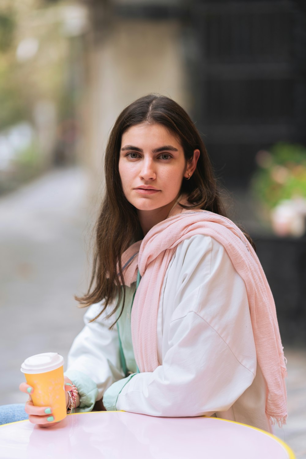 a woman sitting at a table with a cup of coffee