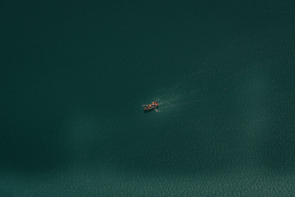 a small boat floating on top of a large body of water