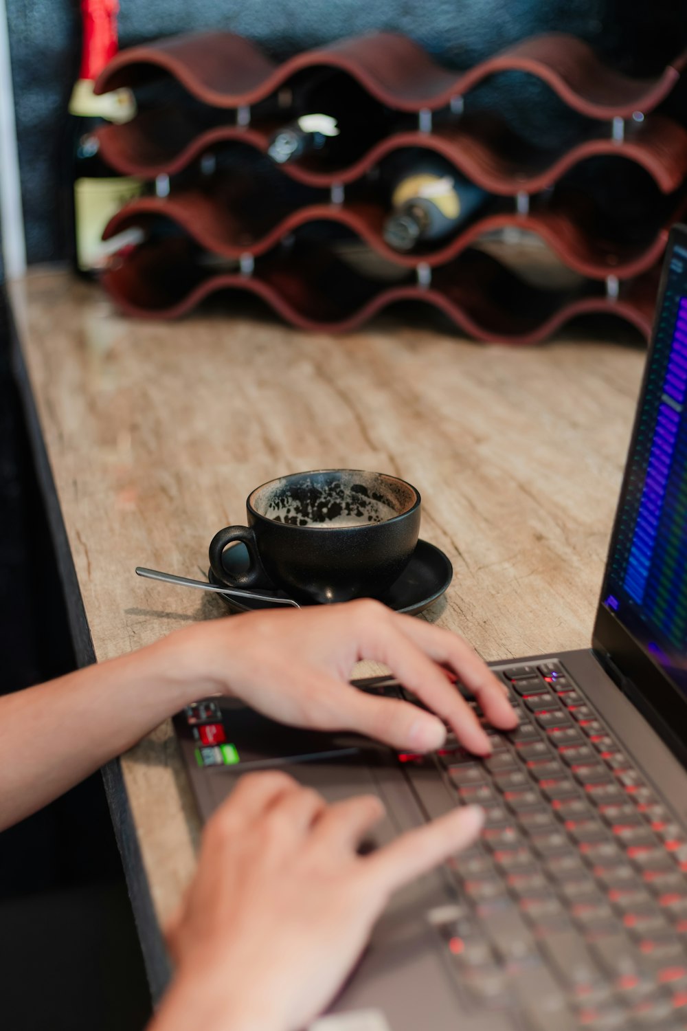 a person using a laptop on a wooden table