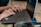 Close-up of hands typing on a laptop keyboard with coffee nearby.