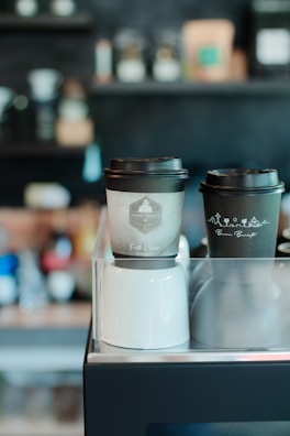 Hot coffee cups with branded sleeves and secure lids for coffee shops.