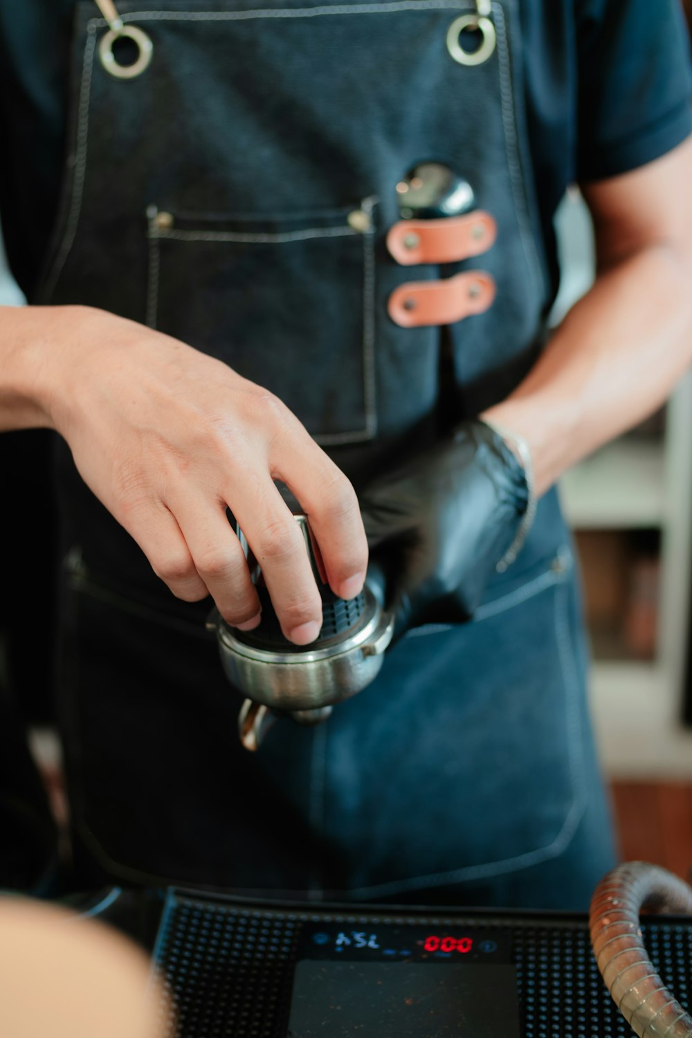 a person wearing an apron and holding a coffee pot