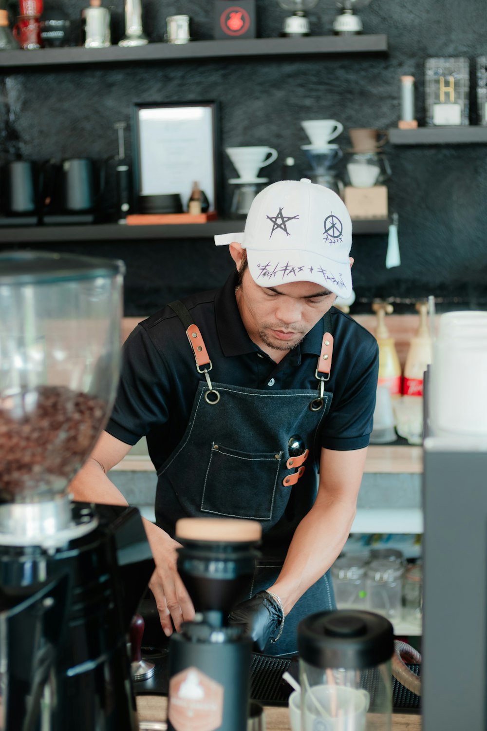a man in an apron and hat working in a coffee shop