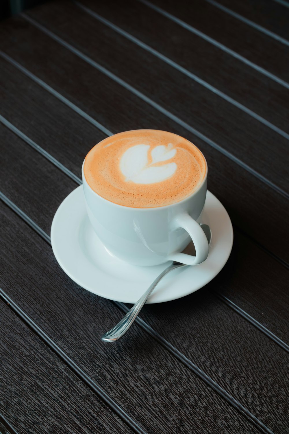 a cup of coffee with a spoon on a saucer