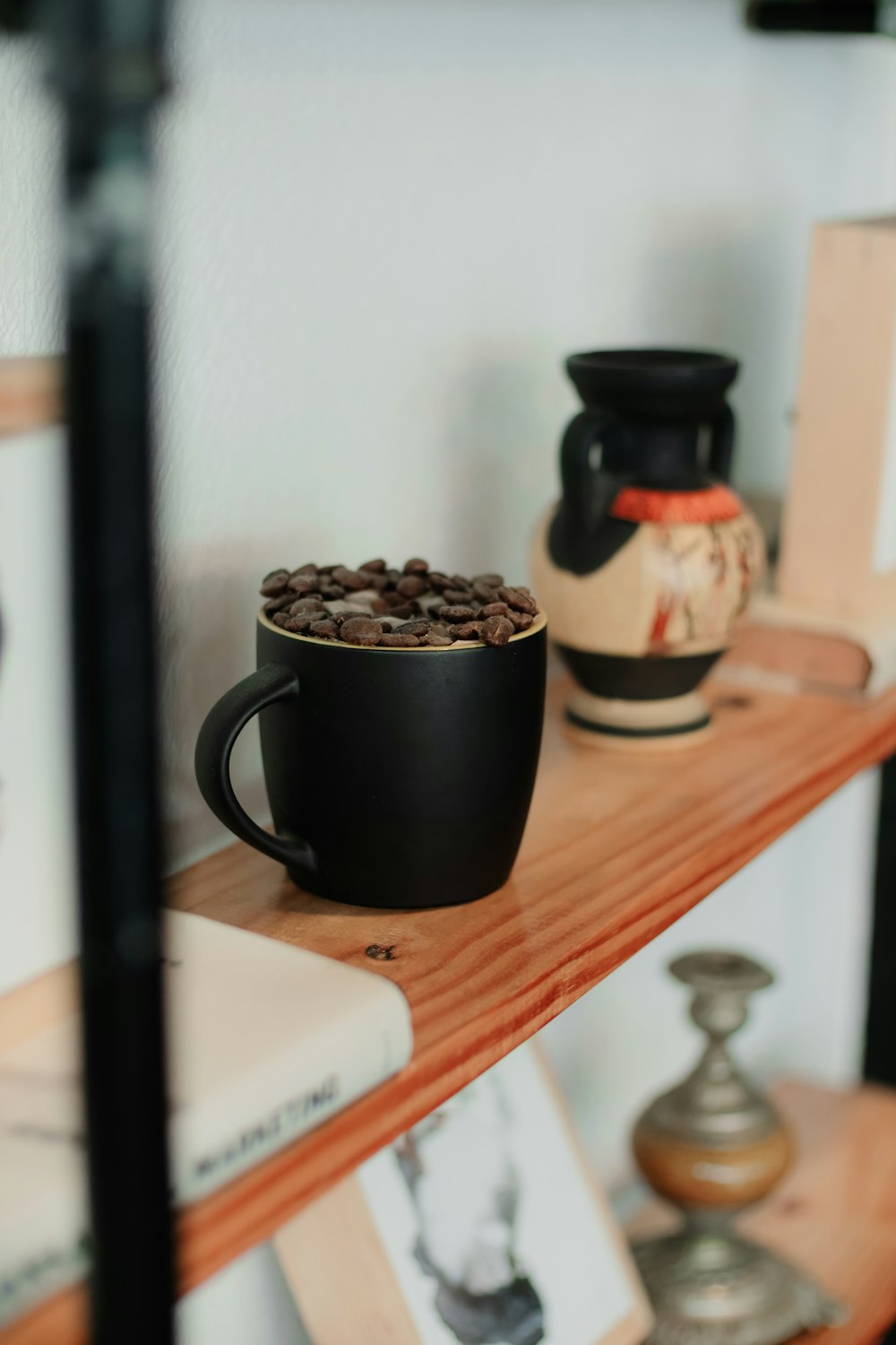 a cup of coffee sitting on top of a wooden shelf