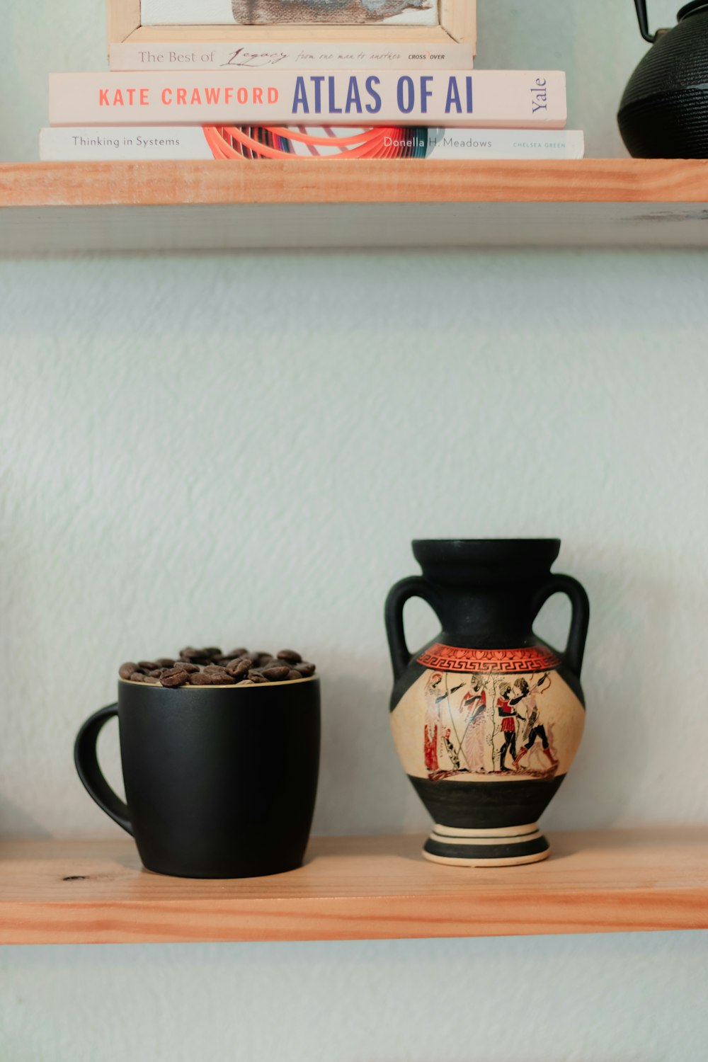 a shelf with a vase and a cup on it