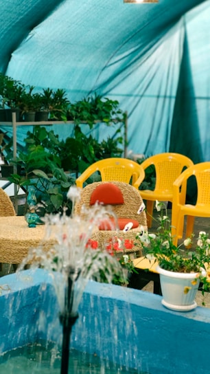 Cozy outdoor seating area with a large stone fountain surrounded by greenery at La Cafetería.