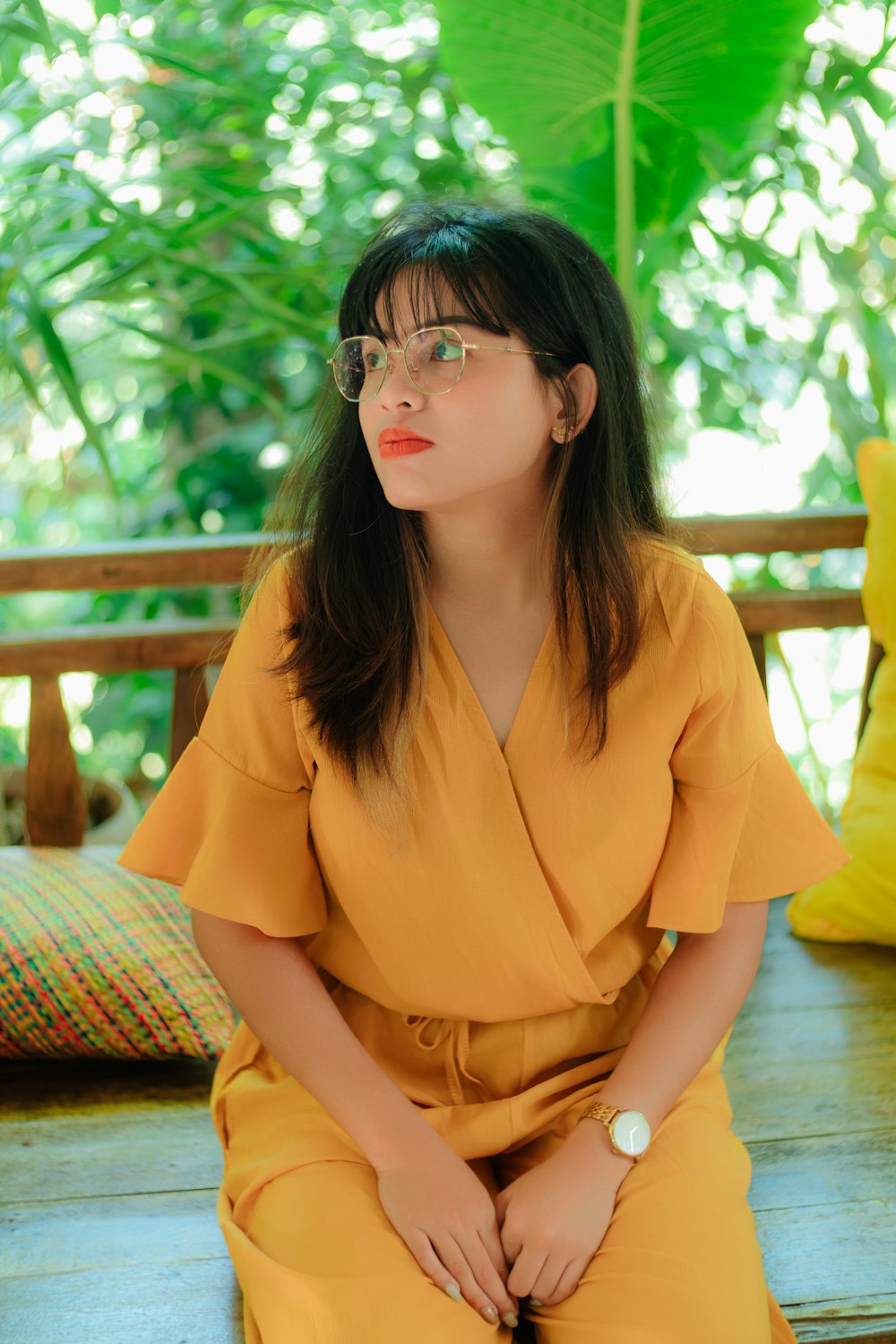 a woman in a yellow dress sitting on a bench