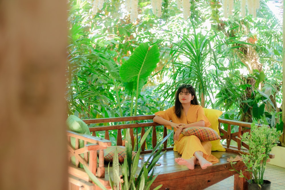 a woman sitting on a bench in a tropical setting