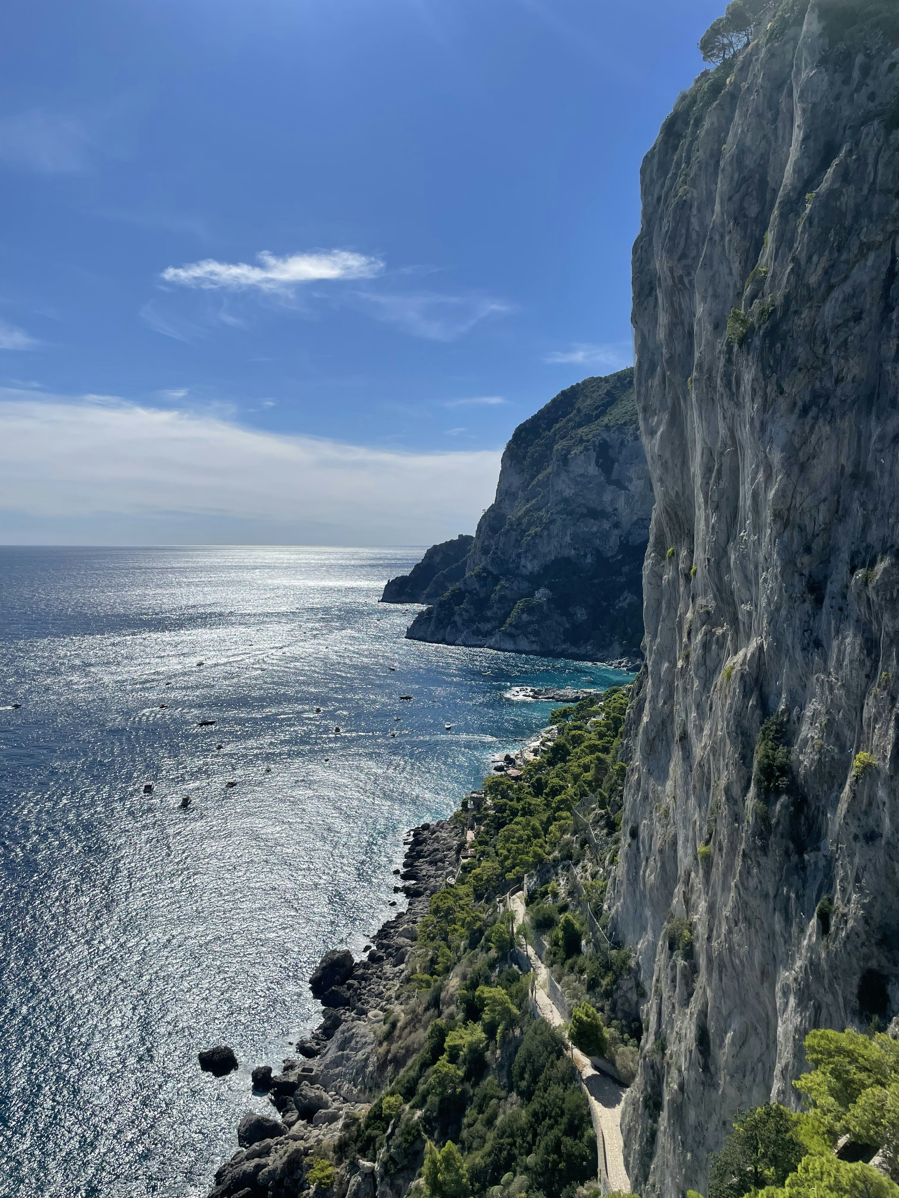 a road on the side of a cliff next to the ocean