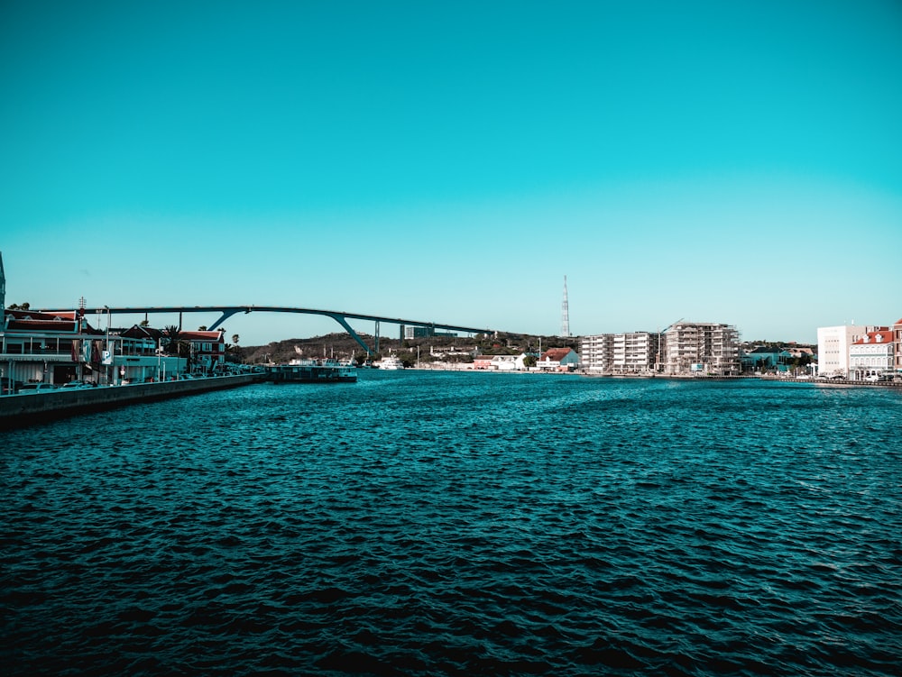 a large body of water with a bridge in the background