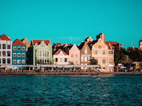 a row of colorful houses sitting on the shore of a body of water