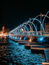 a long bridge over a body of water at night