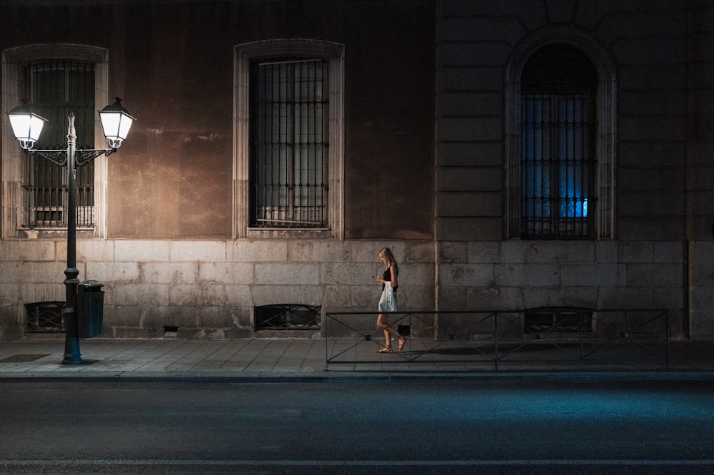 a woman walking down a street at night