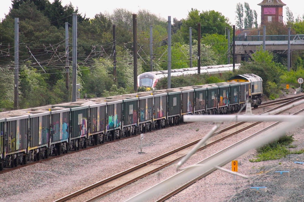 a train is traveling down the tracks with graffiti on it