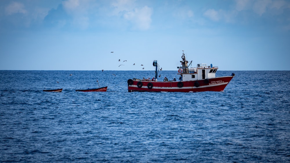 a red and white boat floating on top of a body of water