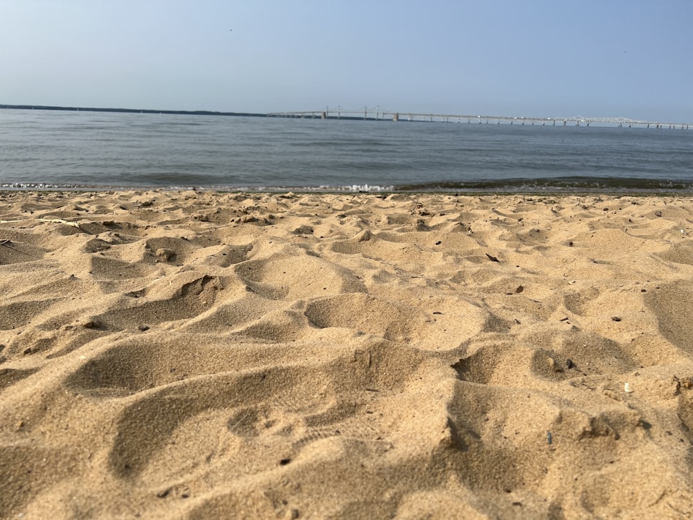 a sandy beach with a body of water in the background