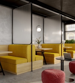 a room with yellow couches and a laptop on a table