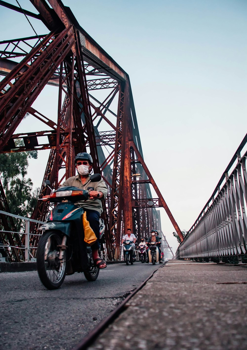 une personne conduisant une motocyclette sur un pont