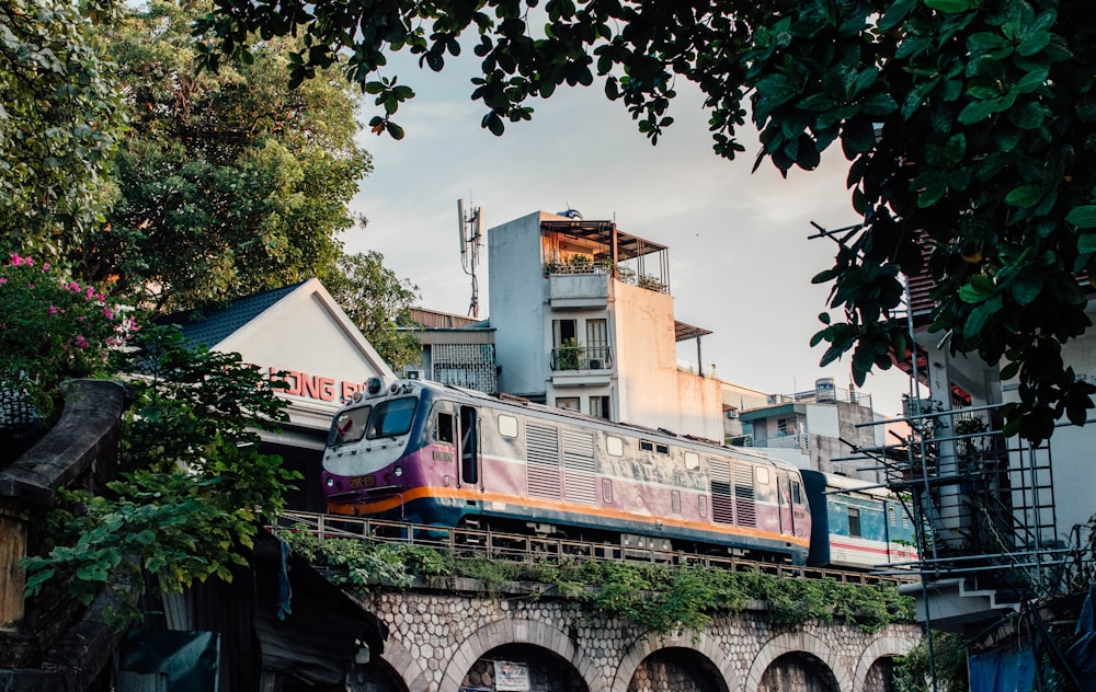 a train traveling over a bridge next to a tall building