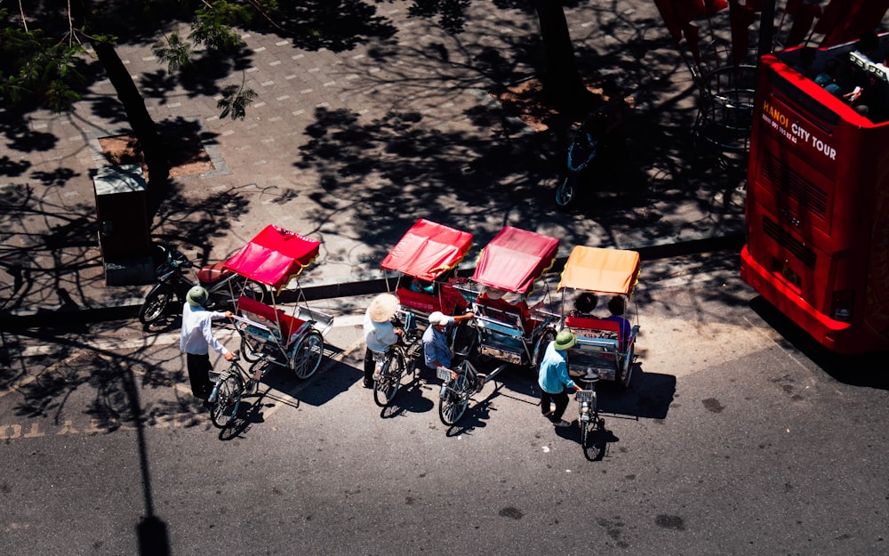 a group of people riding bikes next to a red double decker bus