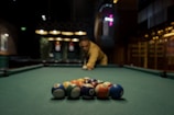 a man leaning over a pool table with eight balls