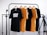 Four t-shirts, two black and two yellow, are hanging on wooden hangers from a black metal clothes rack. The shirts have different texts printed on them. There is a camera tripod on the right side of the frame. The background is a white brick wall.