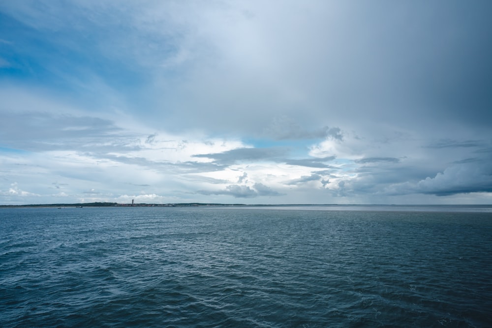 a large body of water under a cloudy sky