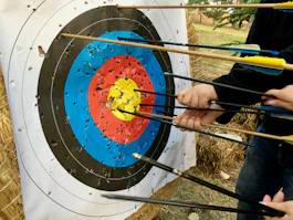 a group of people holding arrows in front of a target