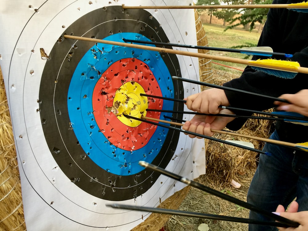 a group of people holding arrows in front of a target