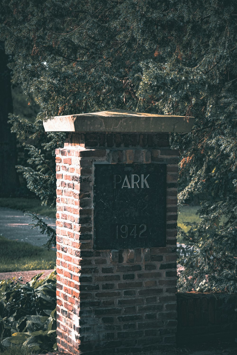 a brick sign in front of some trees