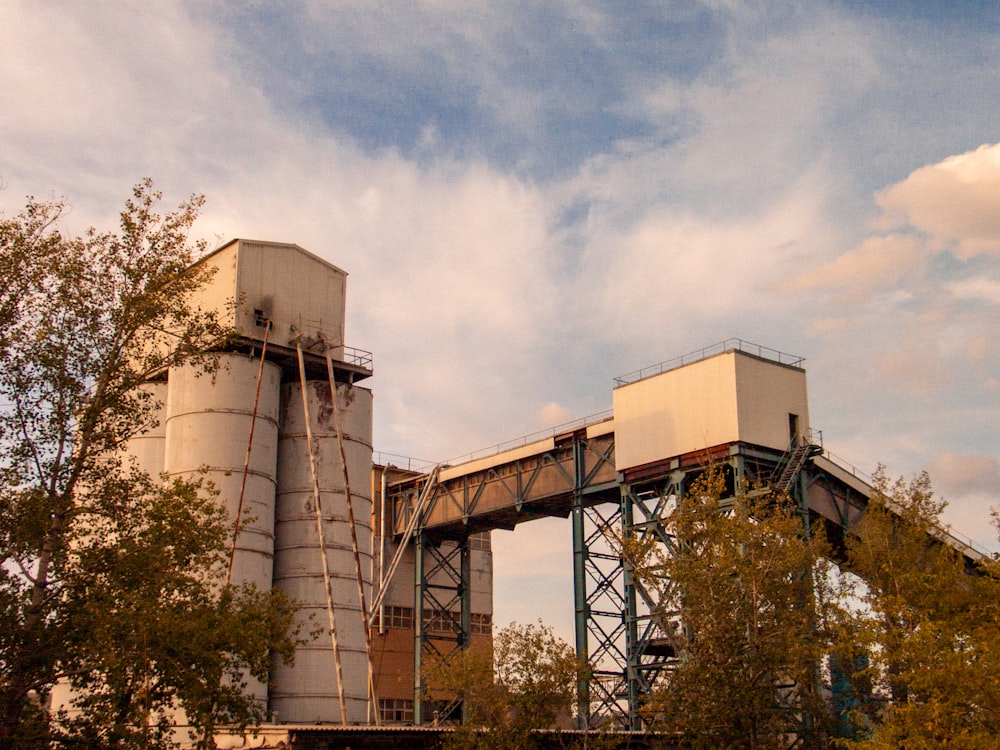 a large cement silo sitting next to a tall bridge