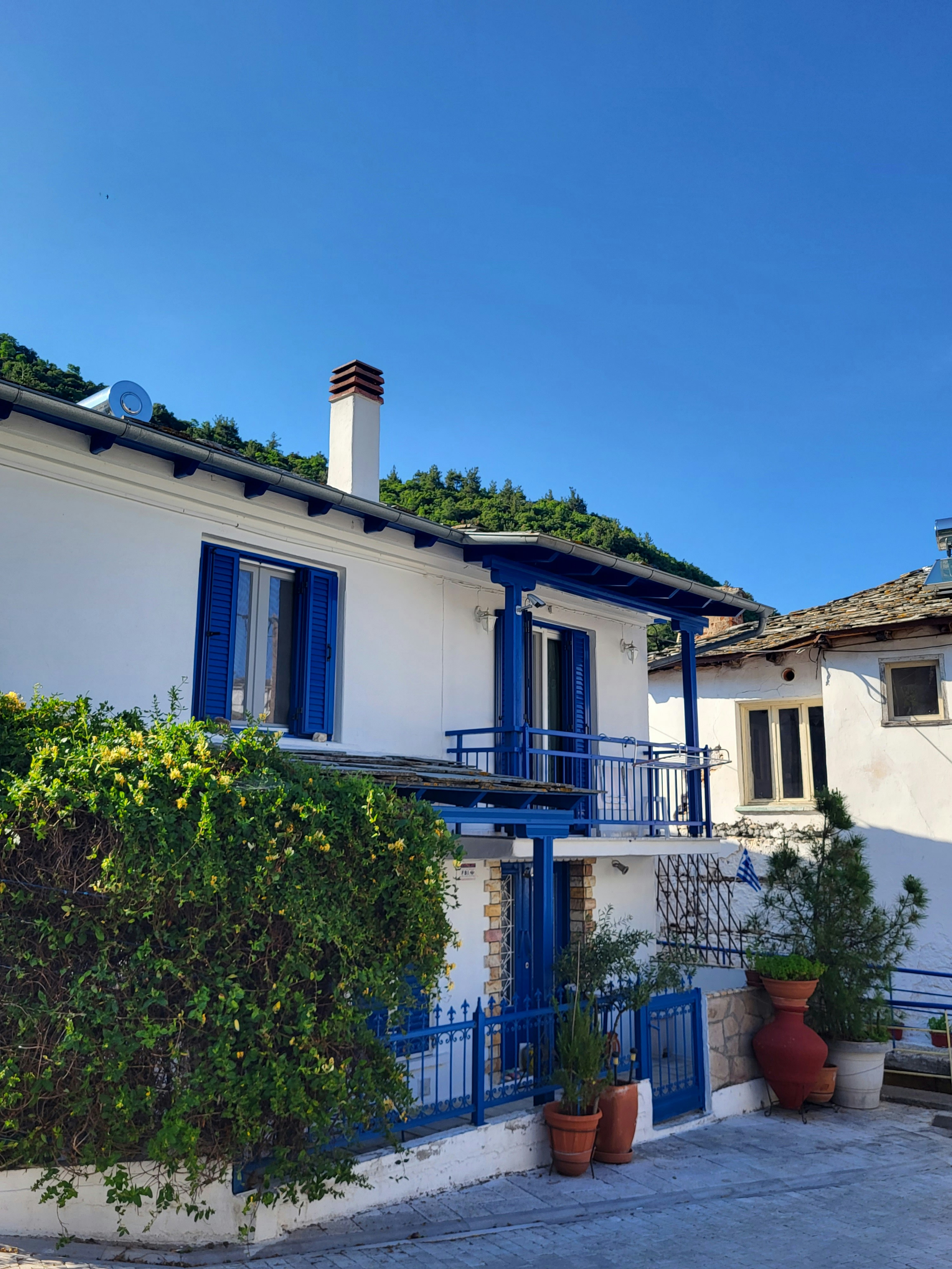 a white house with blue shutters and a balcony
