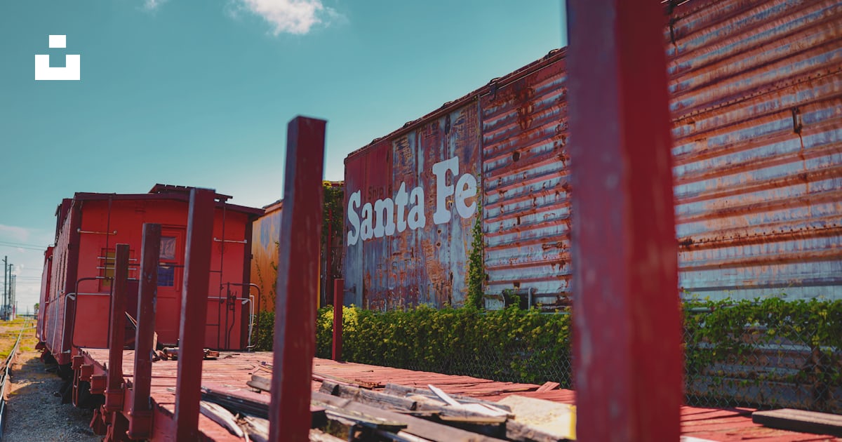 A red train car sitting next to a train track photo – Free Galveston