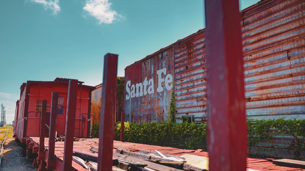 a red train car sitting next to a train track