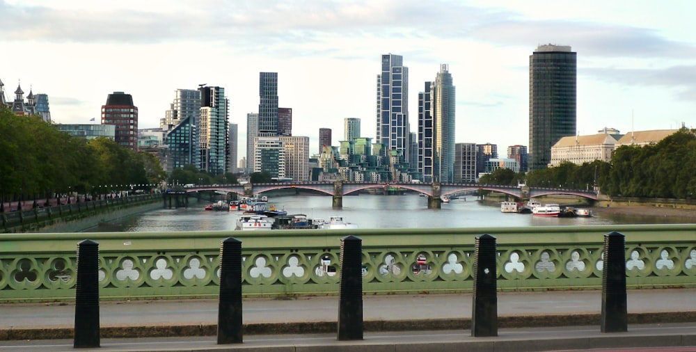 a bridge over a river with a city in the background