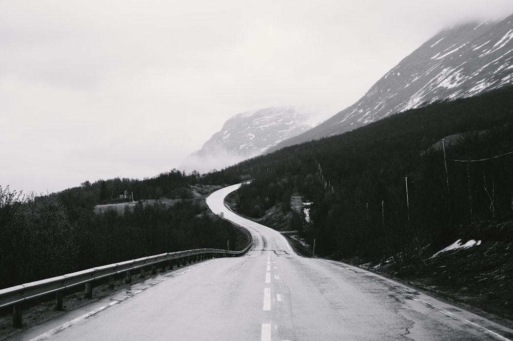 a black and white photo of a road in the mountains