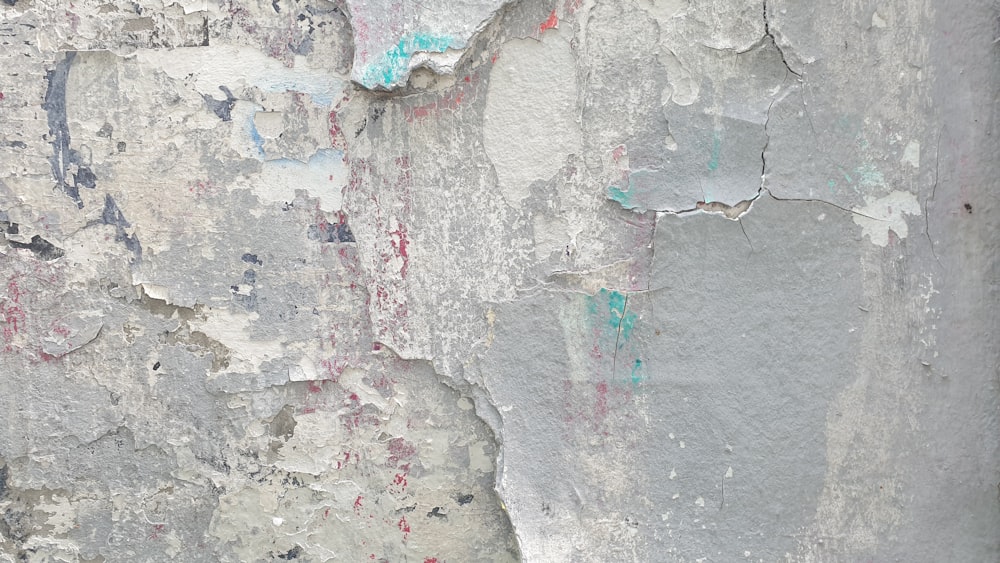 a red fire hydrant sitting on the side of a cement wall