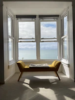 Bright junior suite with modern furnishings and a large window overlooking the sea.