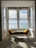 A bright, freshly cleaned living room with sunlight streaming through seaside windows.