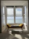 A bright, freshly cleaned living room with sunlight streaming through seaside windows.